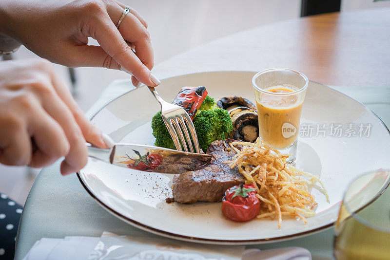 年轻女子在吃炸牛排