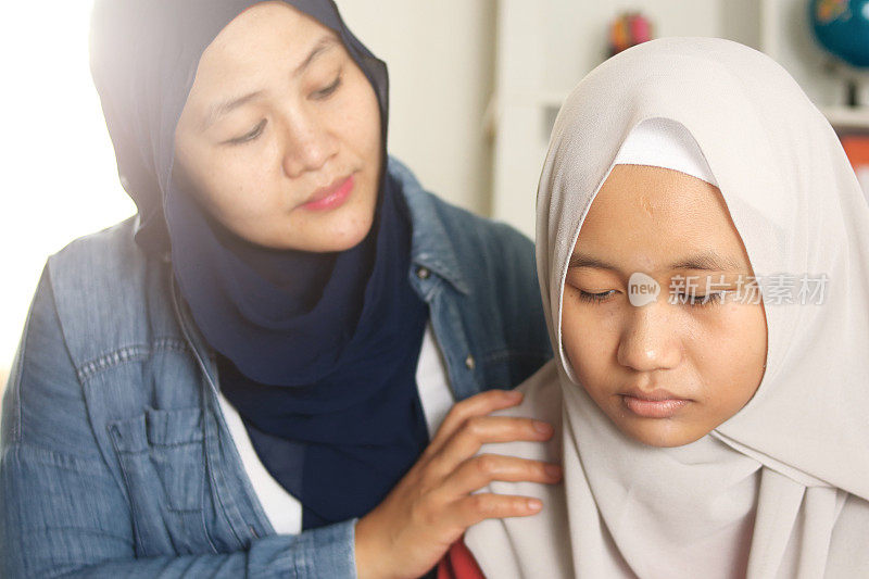 穆斯林母亲安慰她悲伤的女儿，支持她的母亲帮助她的女儿