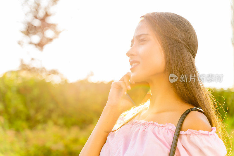 年轻漂亮的女孩用手机，镜头光晕