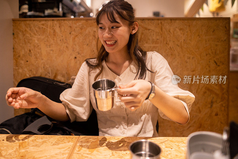 餐馆里拿着杯子的年轻女子