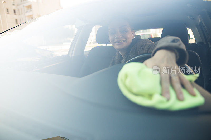 一个女人在用布清洁她的车里