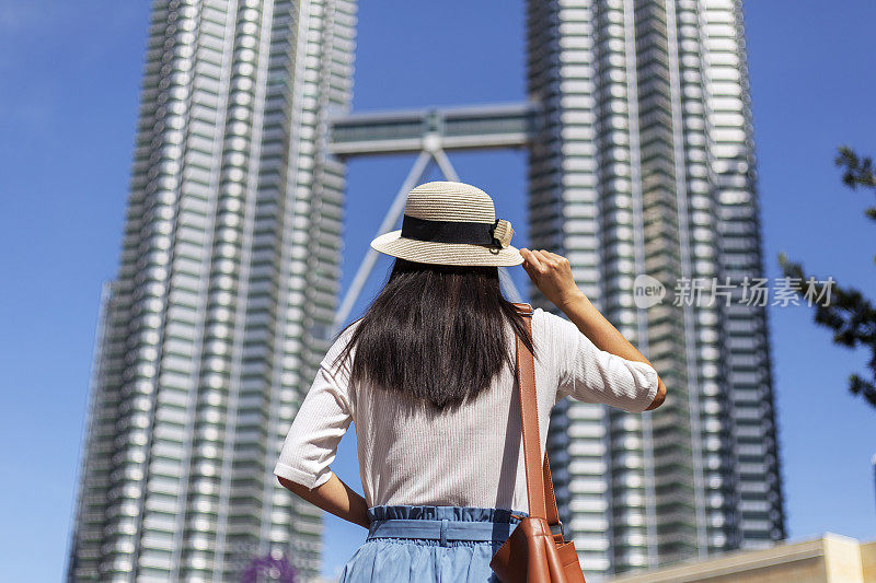 女游客观光吉隆坡地标，马来西亚双子星塔著名景点