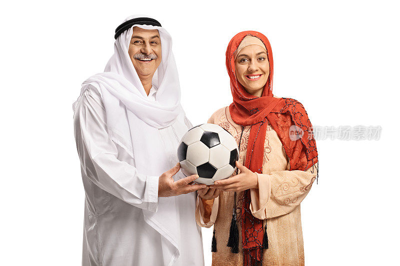 一个成熟的穆斯林男子和一个年轻女子手拿足球在一起