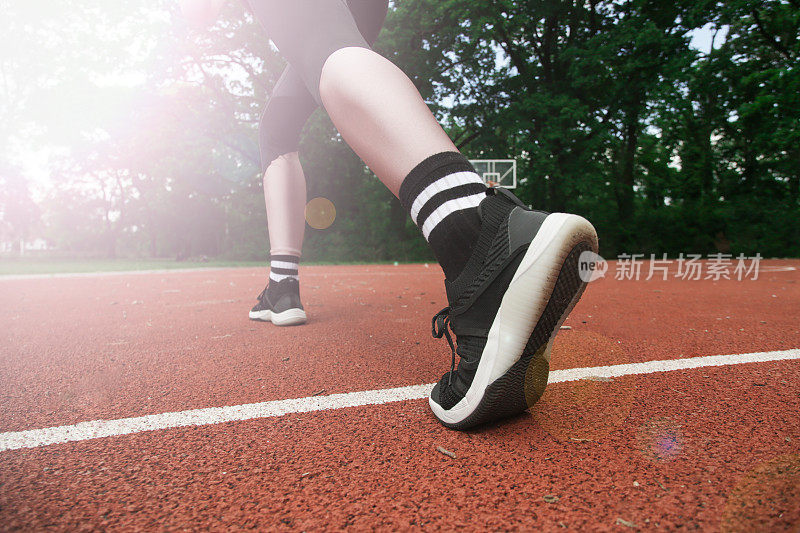 一个运动员在运动场上的运动鞋的特写。户外活动与运动，定格行动。