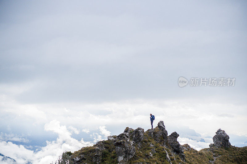 清晨，徒步旅行者在长满青草的山顶上休息