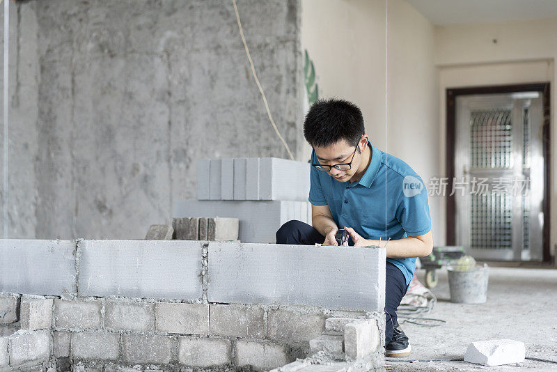 亚洲男性工程师与卷尺工作在翻新工地