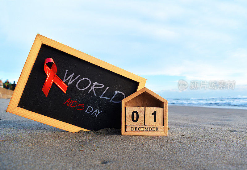 世界艾滋病日红丝带黑板和日历12月1日蓝天，艾滋病意识概念