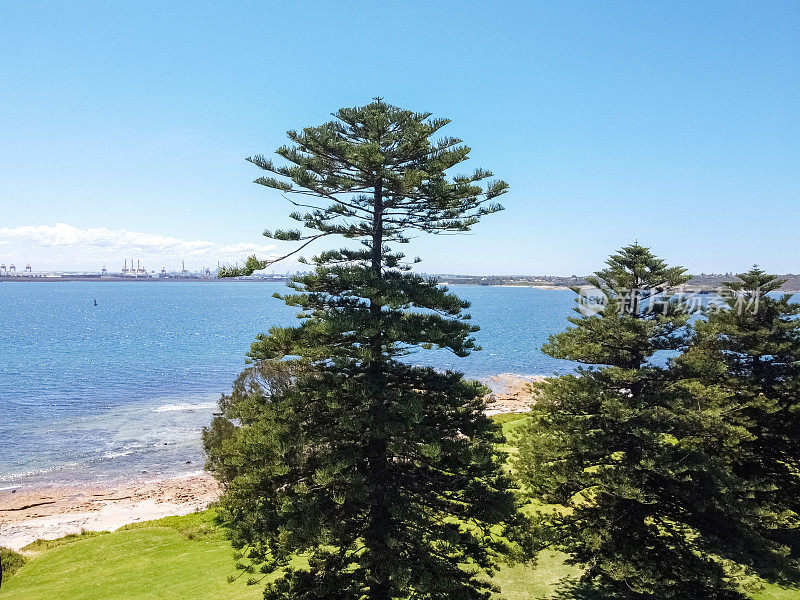 岩石海岸线的Arial视图与城市在远处，背景与复制空间