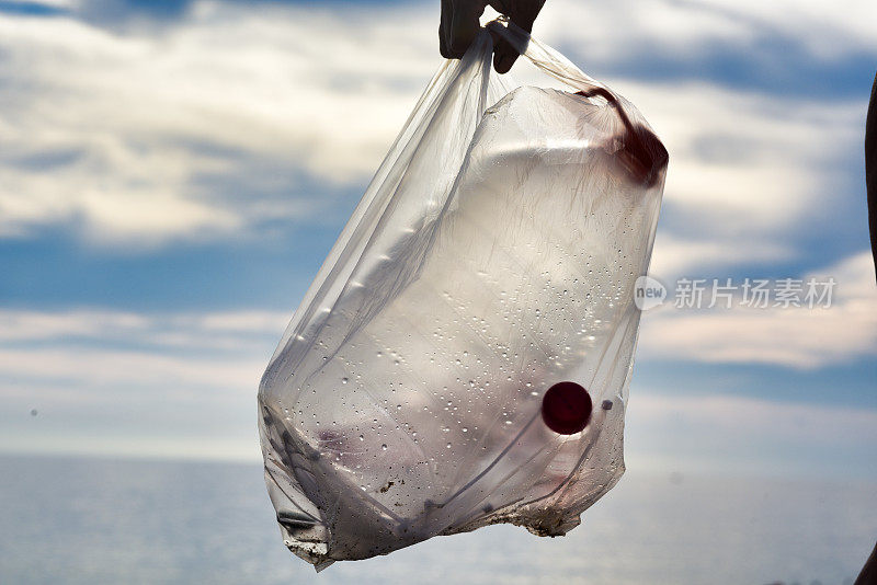 在海滩上捡塑料垃圾