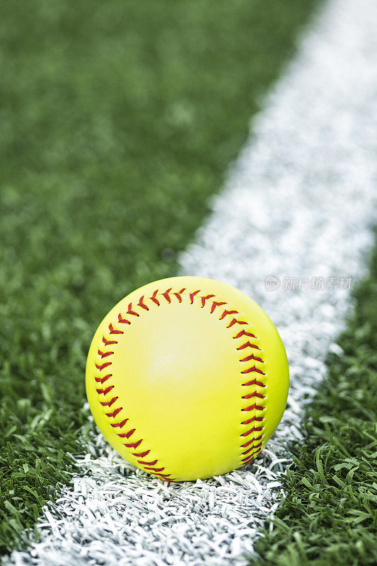 垒球:放在白底线草皮上的垒球