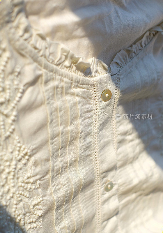 棉白色上衣与阳光，时尚抽象背景，特写