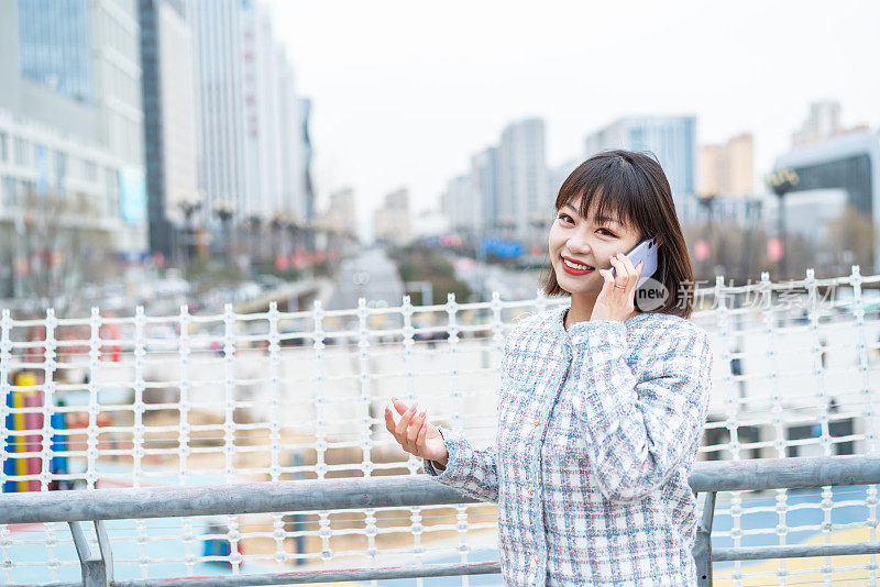 亚洲年轻女子在城市街道上使用智能手机