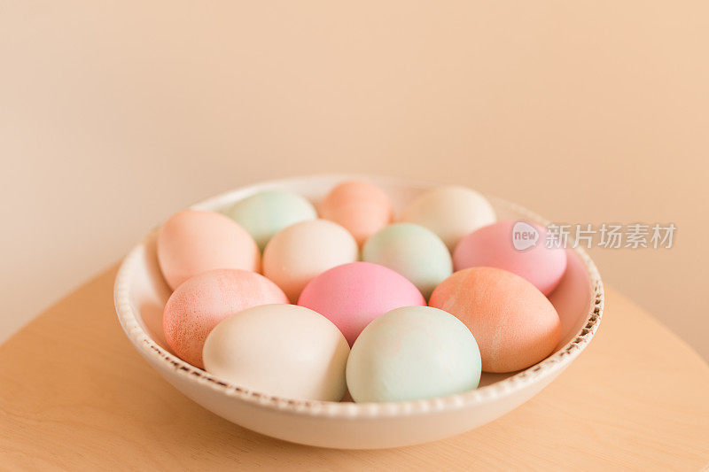 彩色粉彩煮熟复活节彩蛋在一个白色的碗