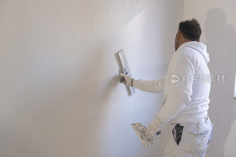 建筑工人正在用灰泥粉刷墙壁