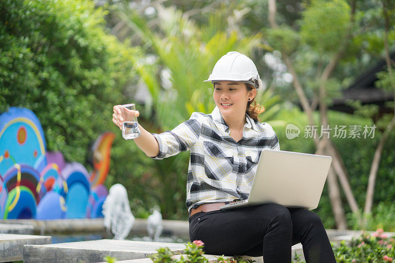 世界环境日理念，泰国亚裔女工程人员手持平板电脑在污水处理厂工作，工程师控制水质，曝气活性污泥池
