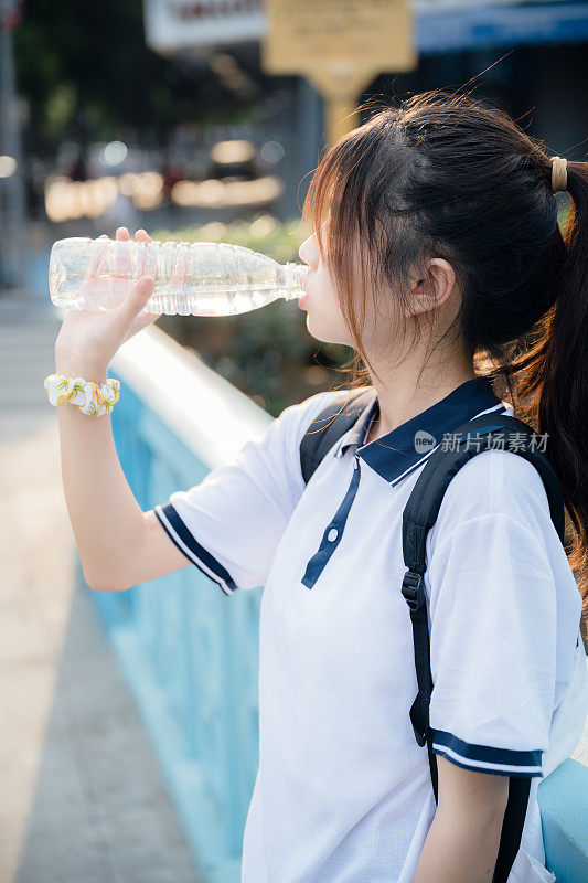 亚洲女孩在阳光下畅饮