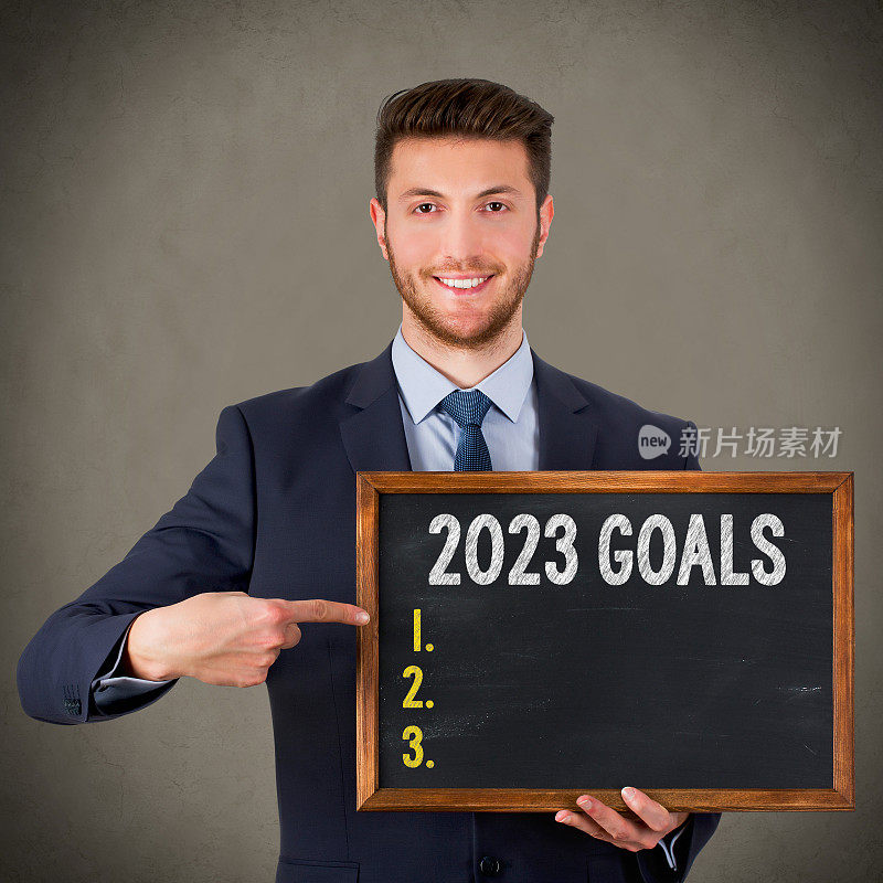 商人在黑板上写2023年的目标