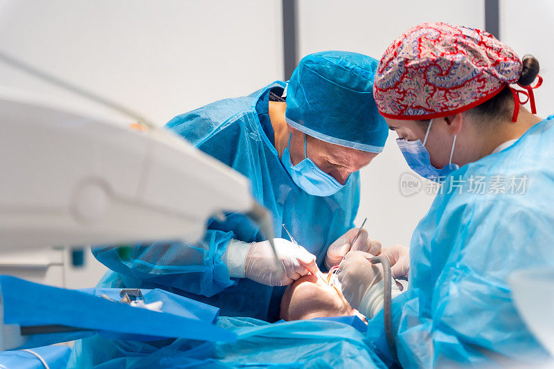 牙科诊所，穿着蓝色西装和帽子的女牙医正在做口腔手术
