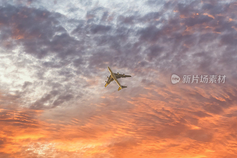 飞机在日落时飞过天空