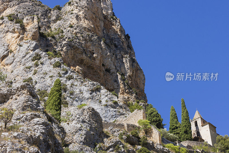 波伏娃圣母院礼拜堂和它的老洛玛巴德塔耸立在穆斯蒂埃村上方的岩石之间