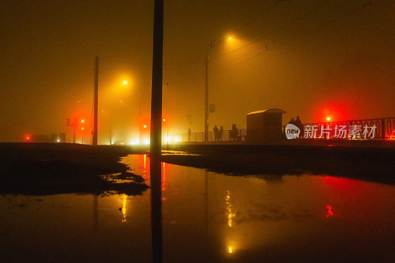 雾。夜晚的城市。潮湿的天气。轮廓