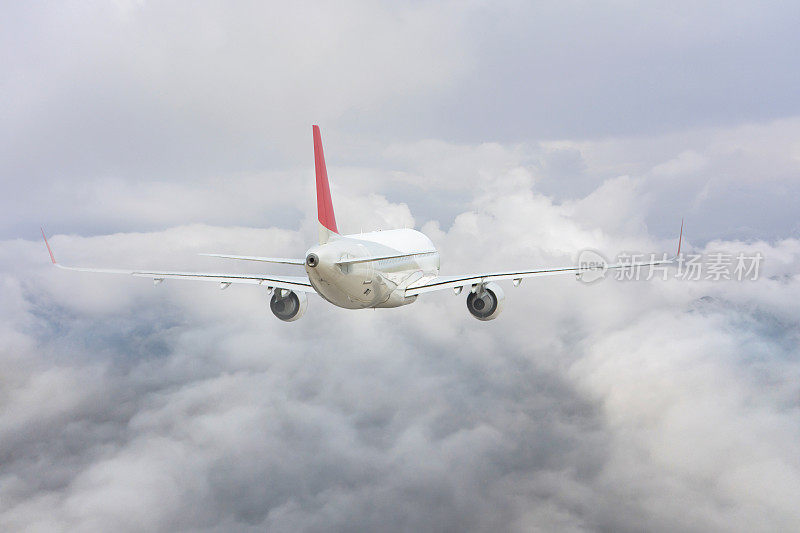 商用喷气式飞机飞越云层。