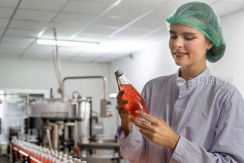 质量控制工程师在果汁或药品的生产和装瓶设备中工作。员工在食品和药品交付给客户之前检查其质量。