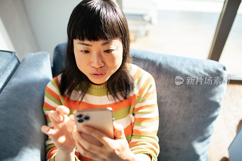 年轻的日本女性在家里使用智能手机