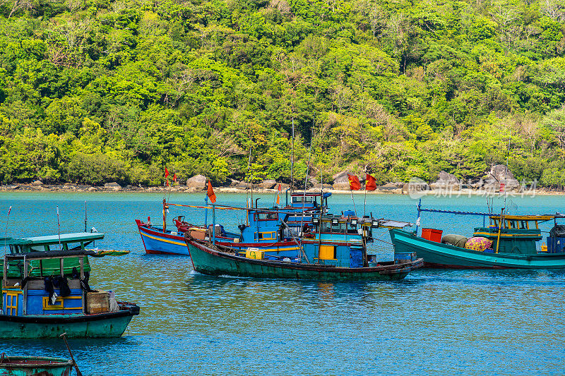 越南孔岛的本坝港，有美丽的碧海蓝天山和五颜六色的小船。