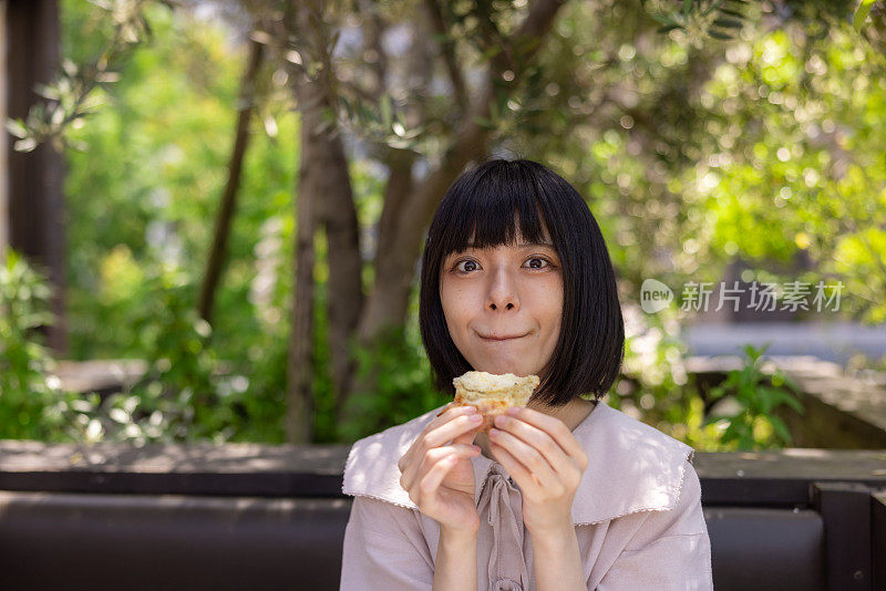 在花园咖啡馆吃披萨的女人