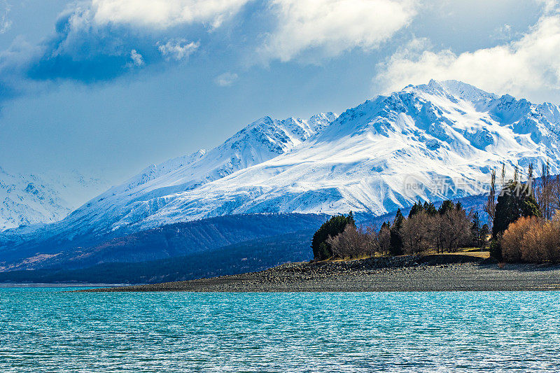 绿松石湖与戏剧性的景观雪山的背景