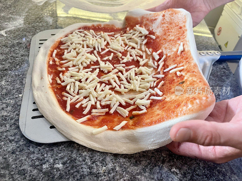 Pizzaiolo把披萨放在铲子上