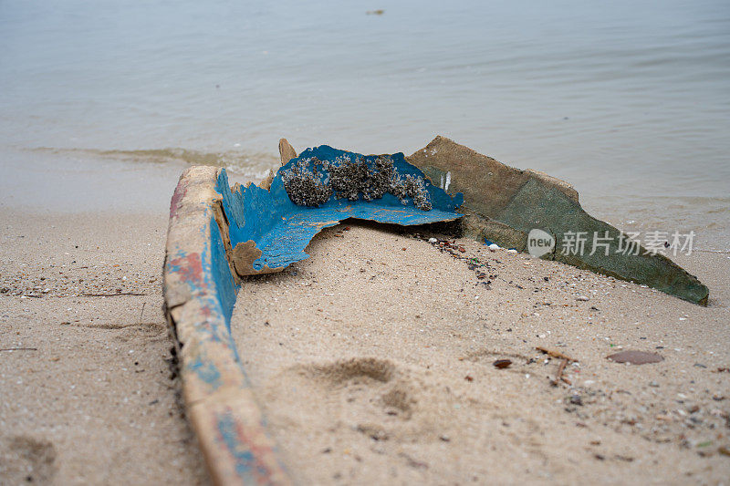 废弃的塑料纤维弃置船被冲到海滩上