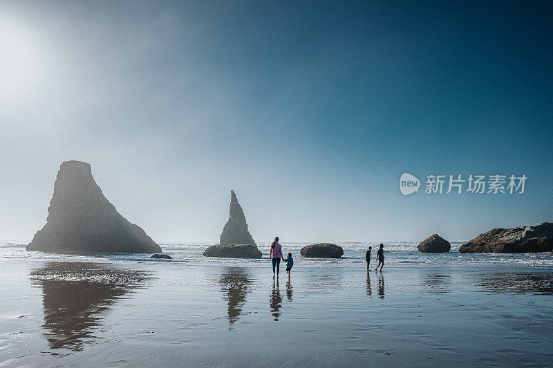 孩子们在沙滩上追逐海浪的广角镜头