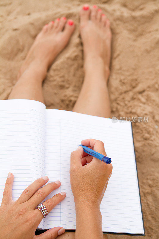 在海滩上写作的女人