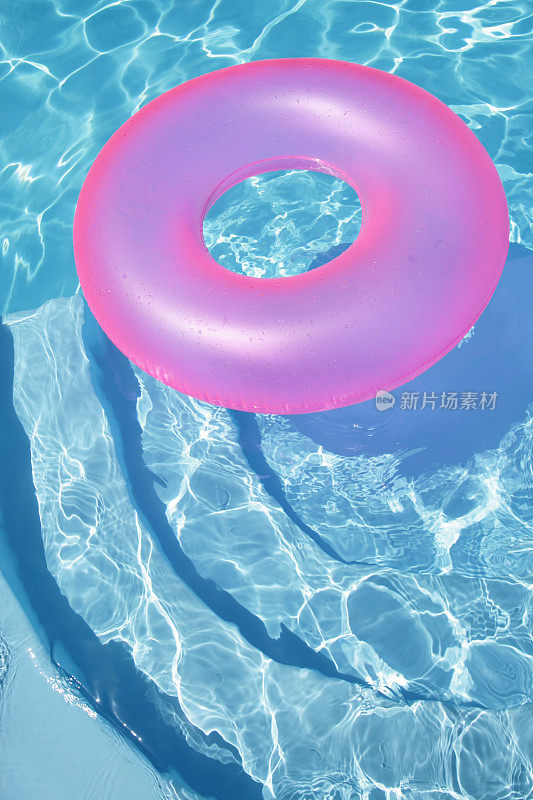 粉红色的戒指漂浮在蓝色的水池里