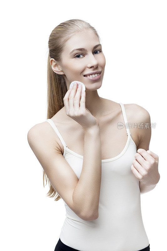 年轻的金发女人用棉垫隔离在白色