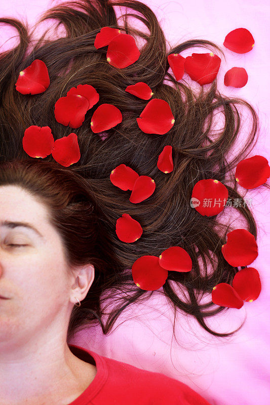 头发上插着玫瑰花瓣的女人
