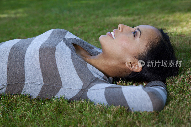 年轻女子躺在草地上做梦