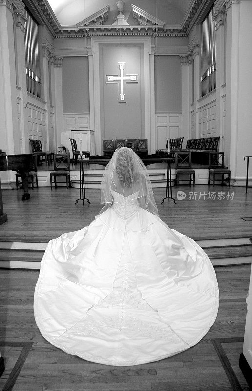 新娘跪在教堂的圣坛前