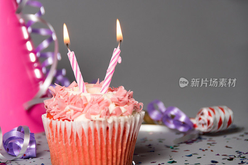 两支蜡烛和派对帽的两岁生日纸杯蛋糕