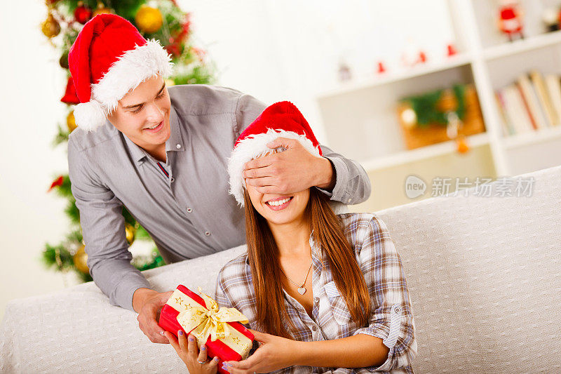 男朋友用圣诞礼物给女朋友一个惊喜。