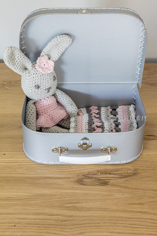 手工编织的玩具兔子坐在玩具箱里