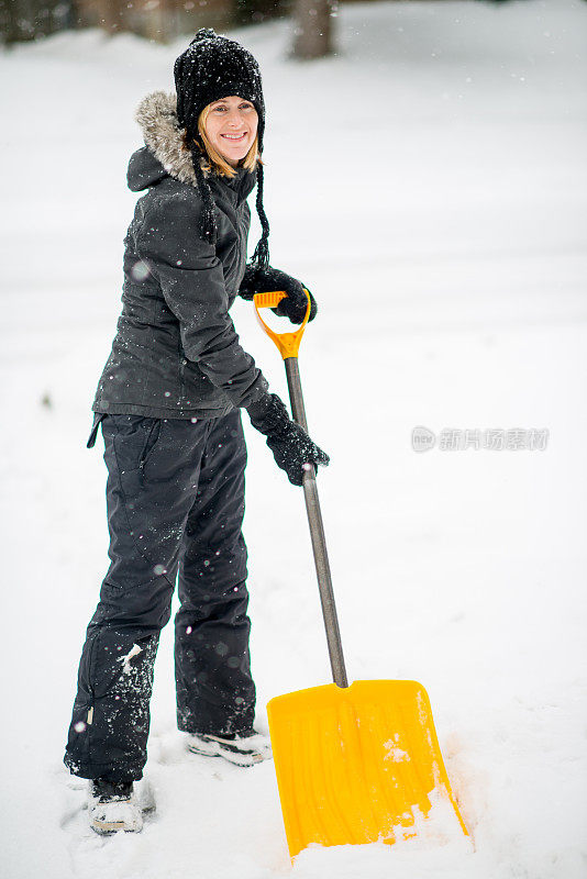 暴风雨后在她的车道上铲雪