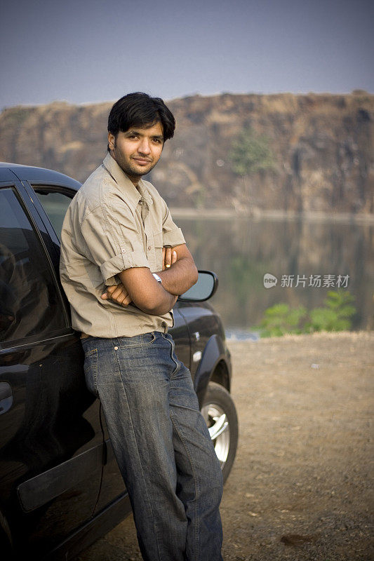 一个快乐的印度亚裔青年男性汽车人垂直户外