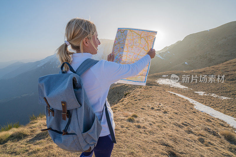 一个年轻女子在瑞士徒步旅行，看地图