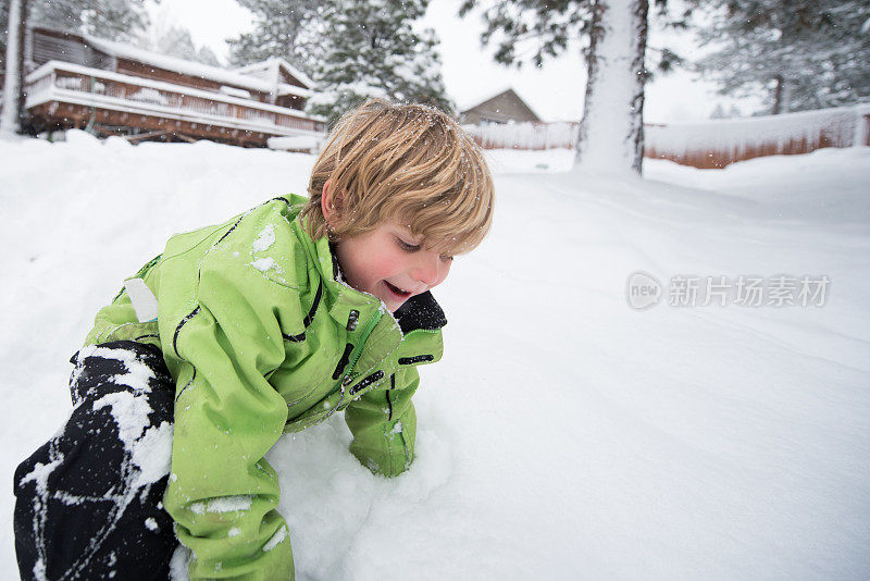 男孩在后院的深雪中玩耍