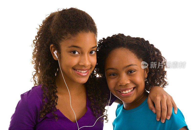 两个十几岁的女孩共用耳机听音乐