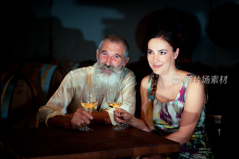 资深男子和美女庆祝，葡萄酒，酒窖在斯洛文尼亚