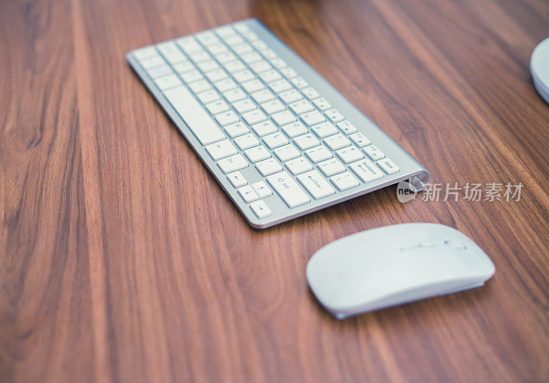 木桌上的白色无线键盘和无线鼠标